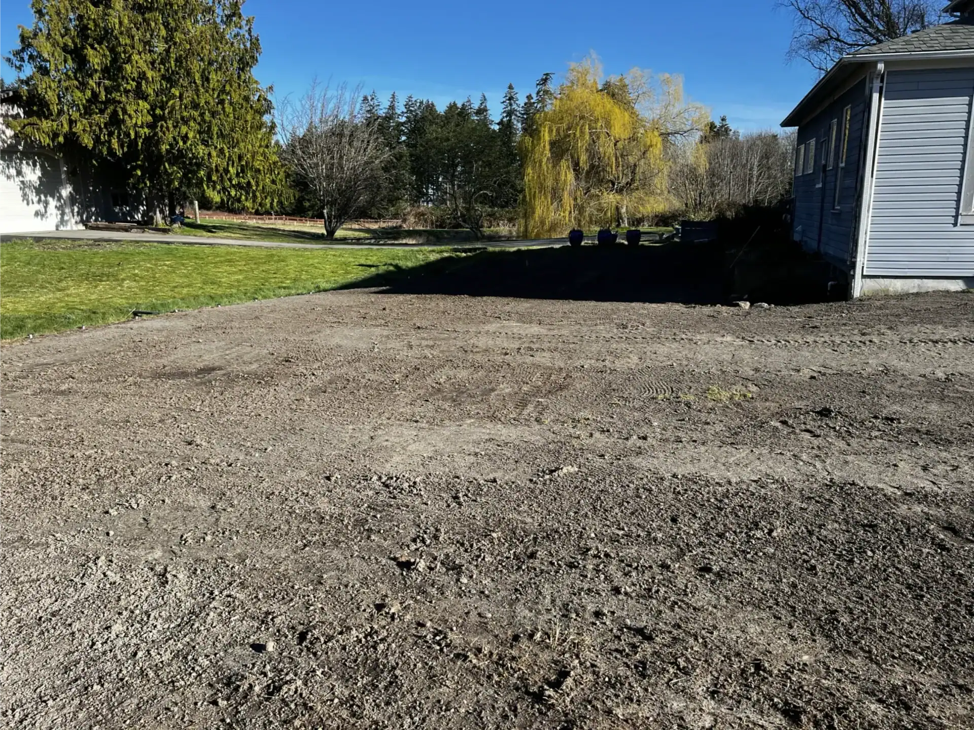 Excavation vs. Grading: What's the Difference? 2 A freshly cleared dirt lot sits adjacent to a blue-gray house